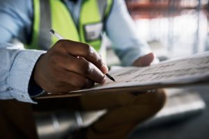 builder filling out paperwork at a construction site