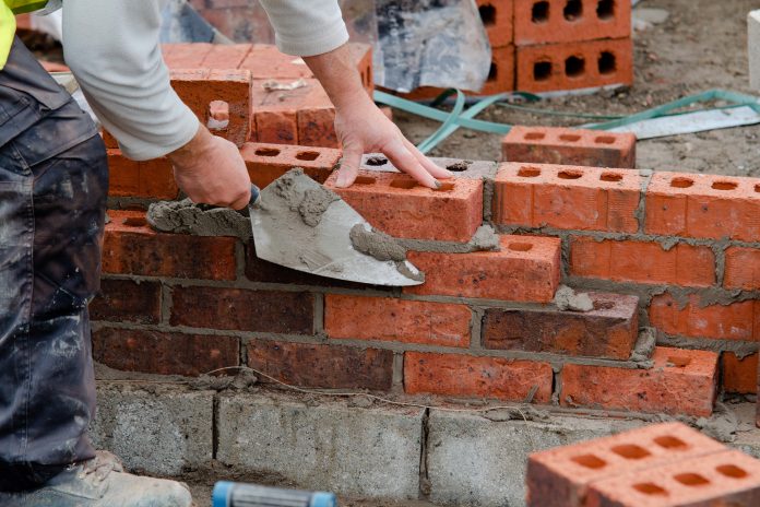 Bricklayer laying bricks - workforce crisis