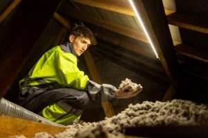 worker installing thermal insulation - blown-in thermal insulation