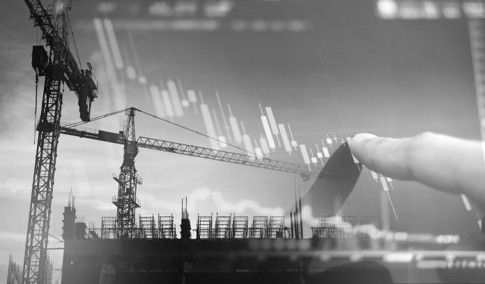 Experts warn of record-breaking wave of insolvencies in construction Investment in real estate business. Double exposure, finger pointing on decreasing graph and building construction