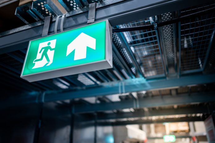 Emergency exit sign or fire exit sign Green emergency exit sign or fire exit sign showing the way to escape with arrow symbol.