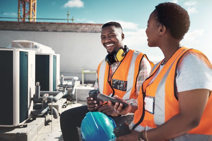 Shot of a young man and woman having a coffee break at a construction site
