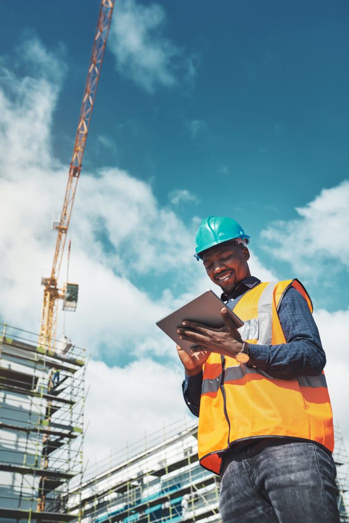 Shot of a young man using a digital tablet while working at a construction site