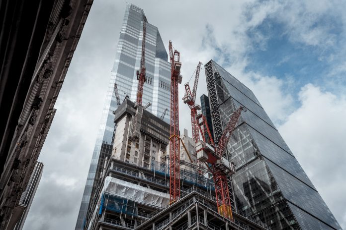 Skyscrapers and construction site with and construction cranes in City of London.
