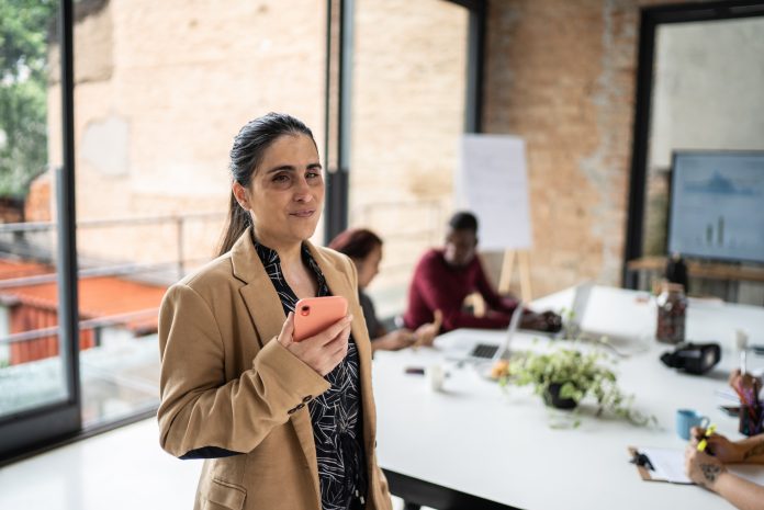Visually impaired businesswoman using smartphone in the office