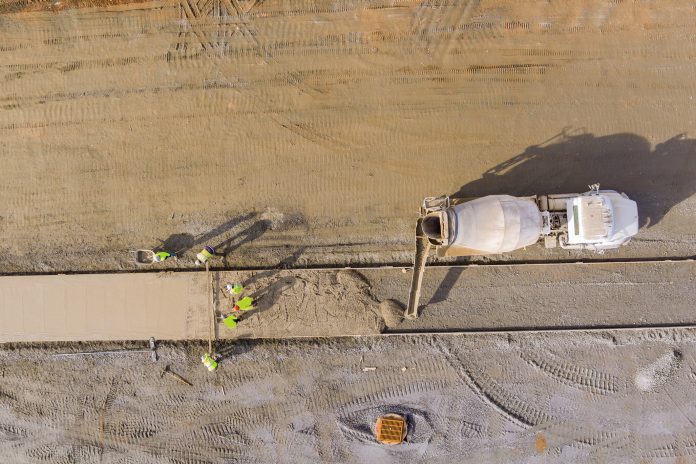 The circular cement value chain: Sustainable and profitable An concrete mix truck pouring concrete at construction site during workers pouring of cement for sidewalk