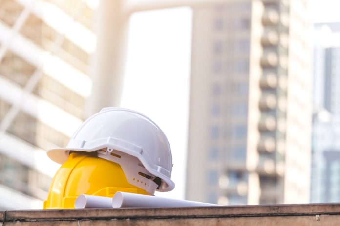 Engineering company fined £200,000 for industrial accident Helmet hat safety on the city background