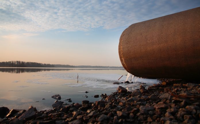 Sewer pipe draining into the sea to represent the water and sewage transformation plan