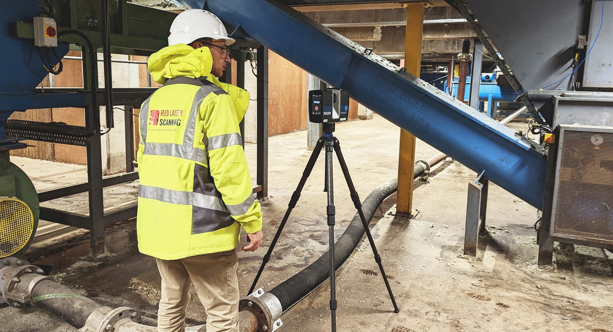 image of worker with 3d laser scanner on site