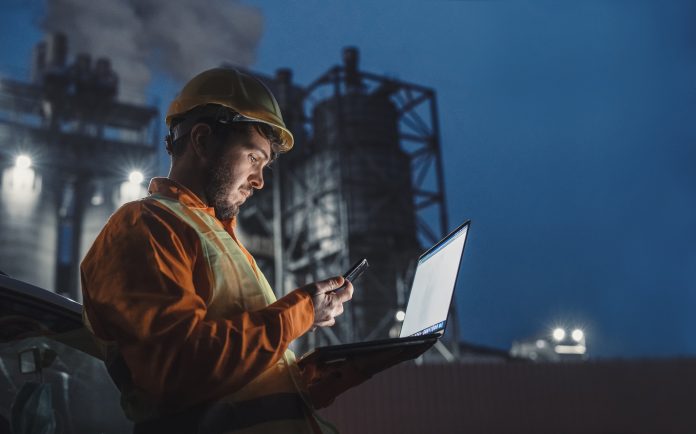 6 ways to guarantee your new construction technology will last Side view of engineer working nightshift and using technology in front of petroleum industrial factory and using laptop and smart phone.