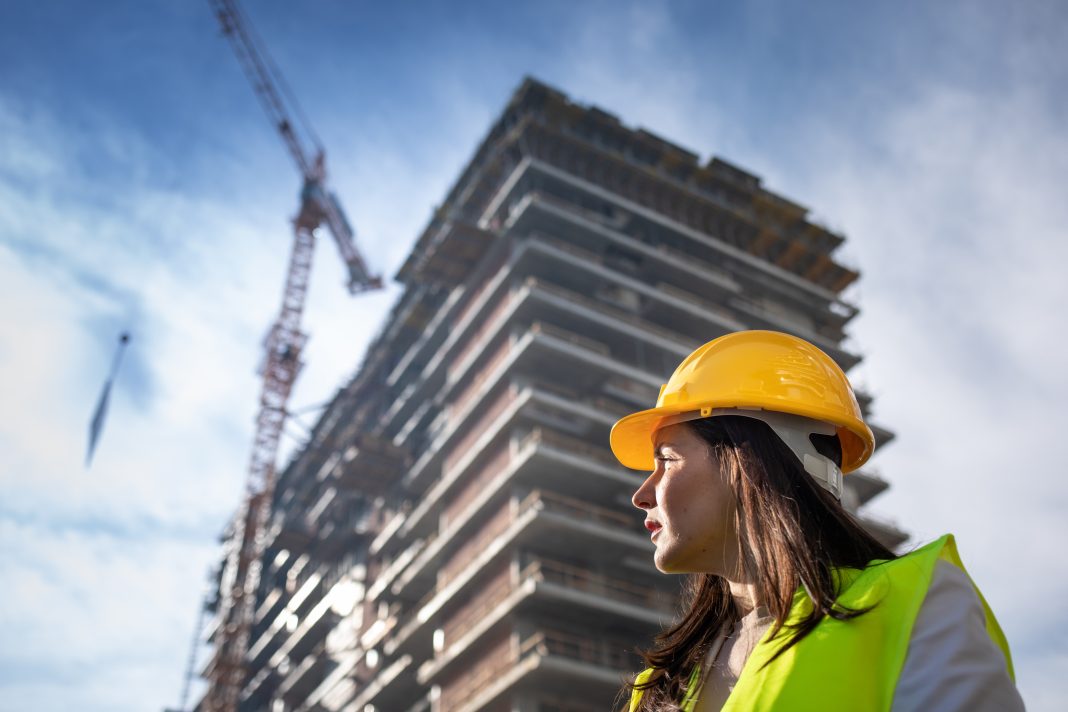 Female architect looking at on construction site, representing a slow increase in project starts