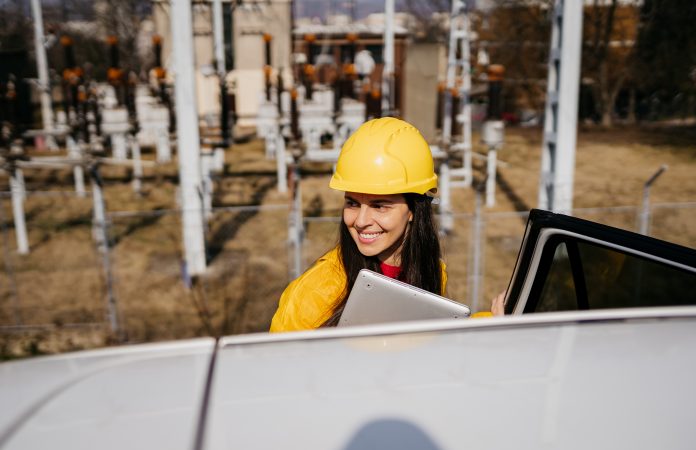 Female electricity engineer leaving the power station, representing Civil engineering practice Perega is celebrating securing the ISO 19650:2:2018 certification, after an 18 month internal review process