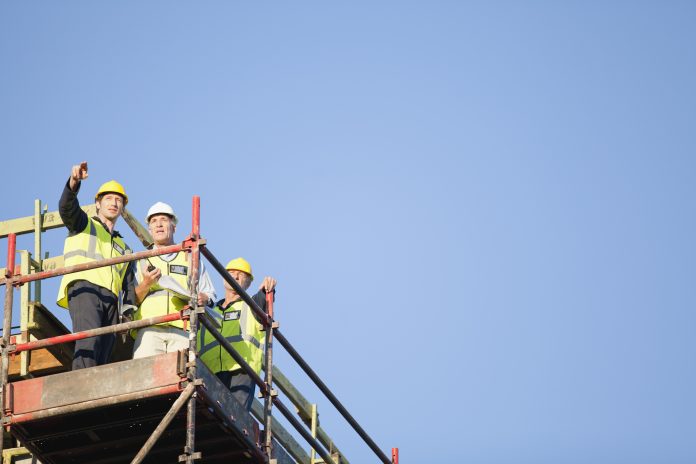 Workers standing on scaffolding on site, representing the potential benefits of collaborative procurement