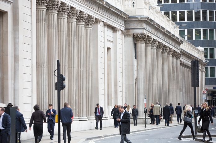 London, UK - October 14, 2015: Business people walking by the Bank of England. Business life of City of London, to represent the 5% interest rate rise