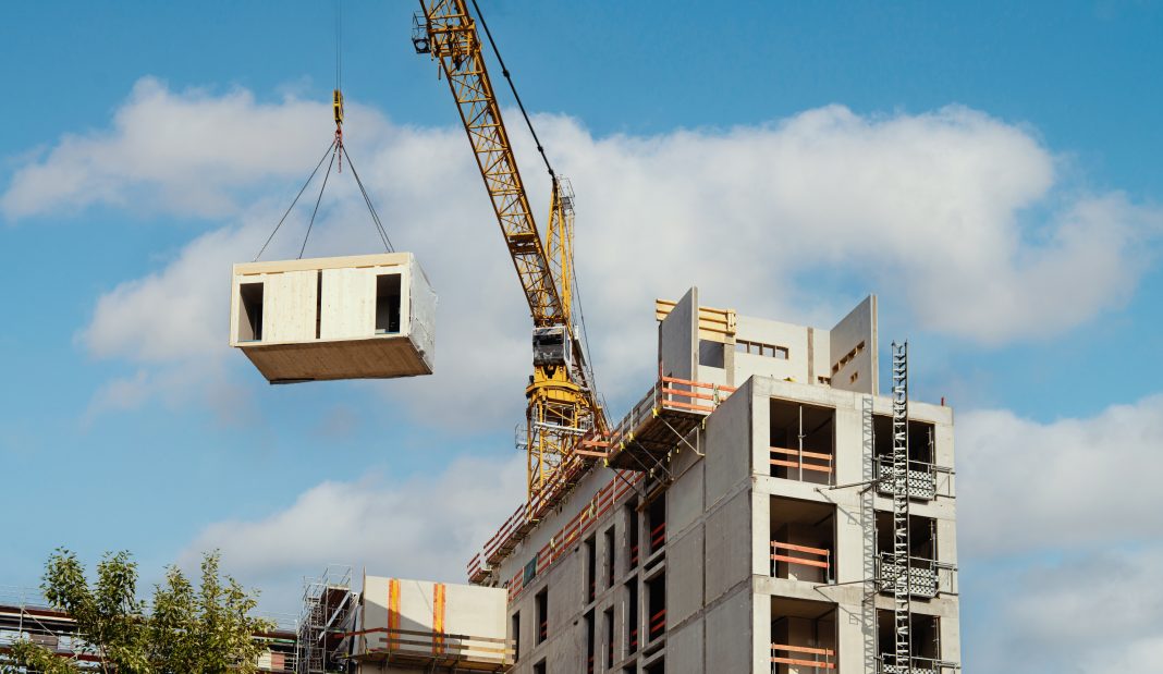 A crane lifts a modular housing component, to represent the latest LHC public sector frameworks
