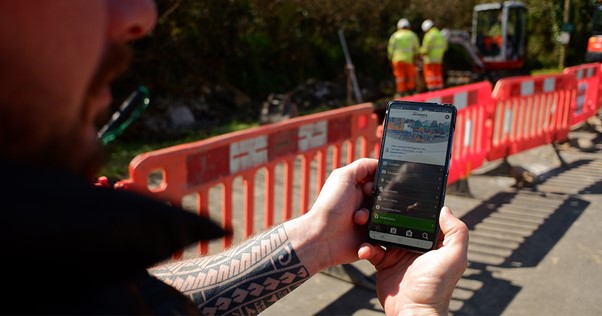 Re-flow field management review by Gregory’s Water Services Man holding phone showcasing Re-flow field management software