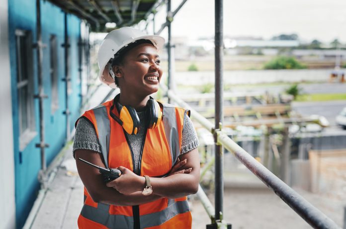 Shot of a young woman working at a construction site, representing technical membership