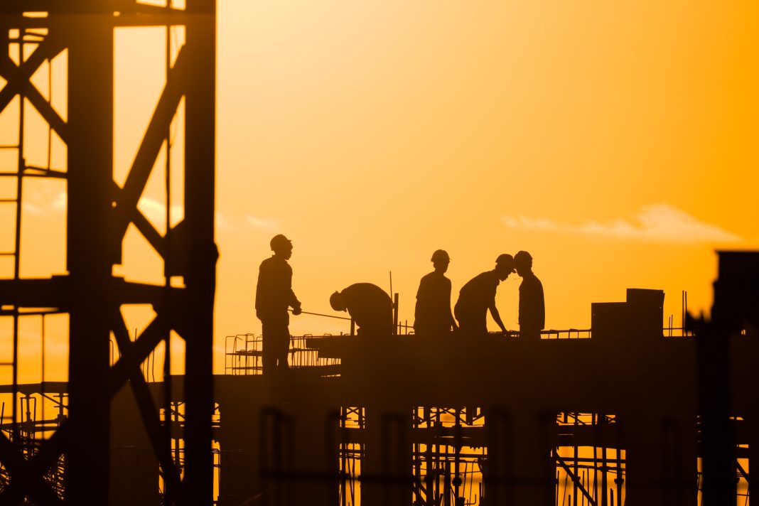 image of construction workers at sunset