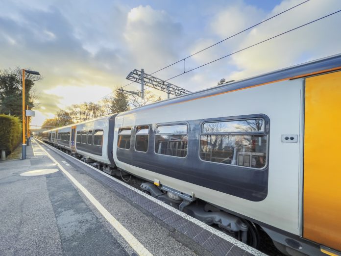 Railways: The backbone of sustainable mobility England UK. An electric powered train passes through the British Rail station, representing ticket office closures
