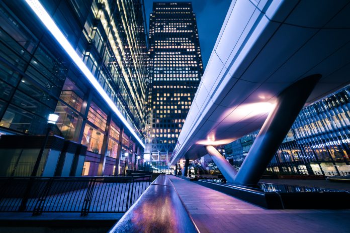 UK National Metric Library: Accelerating change through a performance-led approach luminated office buildings at Canary Wharf, London at Night