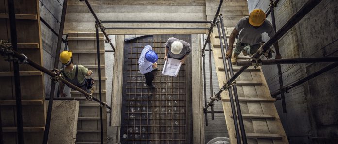 Construction workers and architects at a construction site viewed from above, representing confirmed redundancies at BAM