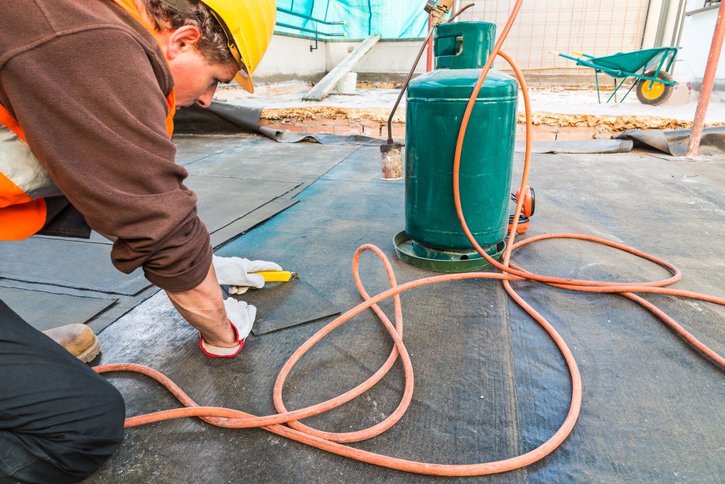 Roofer Installing Rolls Of Bituminous Waterproofing Membrane For The Waterproofing