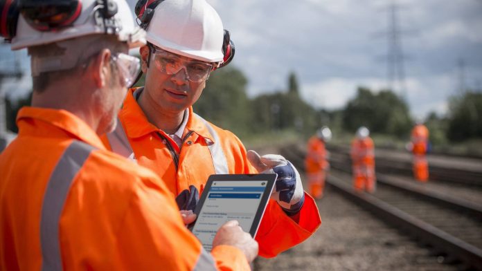 Image of two construction workers using field management software