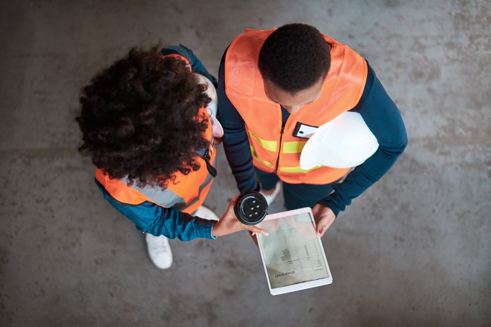 High angle shot of two young women using a digital tablet together in a factory, representing ERP and CRM