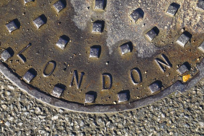 Curved London lettering on studded metal manhole The word London is inscribed on this studded metal manhole / cover in an inverted curve, representing Tideway's super sewer project