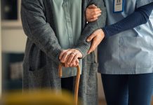 Report reveals £625m annual investment in home accessibility could create up to 100,000 jobs Close up hands of caregiver doctor helping old woman at private clinic. Close up of hands of nurse holding a senior patient with walking stick. Elder woman using walking cane at nursing home with nurse holding hand for support.
