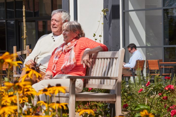 two elderly people sitting on a bench to showcase retirement communities concept