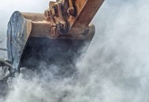 How demolition might be more sustainable than you think Excavator demolishing wall of an old house, representing sustainable demolition