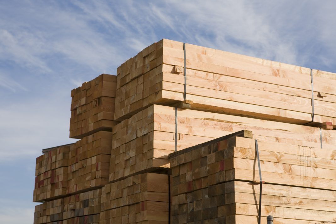 Stacks of lumber in a lumberyard, representing recycled plastic lumber