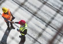 Enhance your safety & efficiency with cloud-based defect management tool Over the head aerial view of a senior man architect and African American engineer shaking hands on construction site.