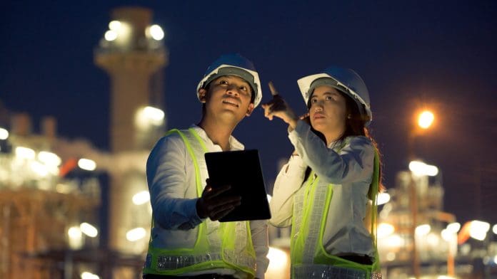 Two industrial engineer using digital tablet for work and discussing against the background of electrical power plant at night time. Imerso's Juha-Matti Halminen explains the growing trend of automation and digitisation in closing the gap between the office and the site