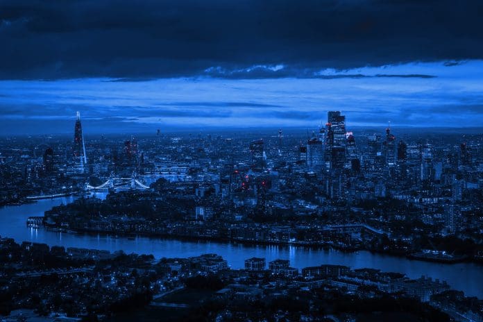 Tysers: Construction insurance and risk management expertise Wide aerial panorama of the illuminated London skyline during evening, England, with River Thames leading into the city, representing construction insurance