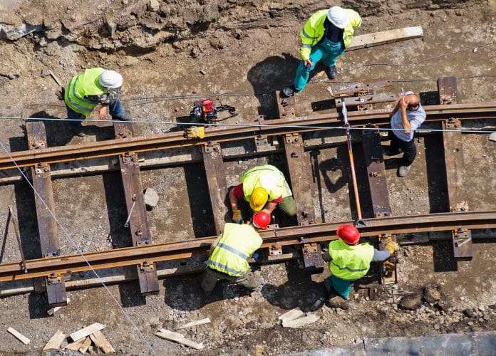 ONS reports reveals a decline in construction output for August Construction output - construction workers on a rail line