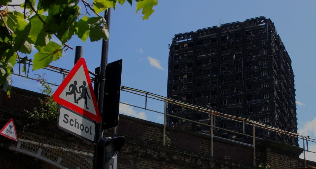 Grenfell Tower Tragedy Grenfell Tower in the background, Children crossing sign in the foreground, reminder of the children affected and who lived in the neighborhood.