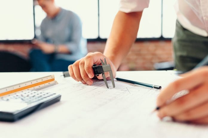 Engineering hands hold vernier caliper working and checking drawing blue print scale on workplace. Engineering hands hold vernier caliper working and checking drawing blue print scale on workplace.