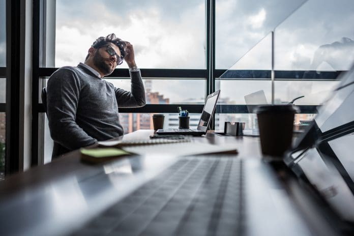 Mid adult businessman thinking of something in the office 93% of SMEs surveyed by the Home Builders Federation cite delays in securing planning permission as a major barrier to growth