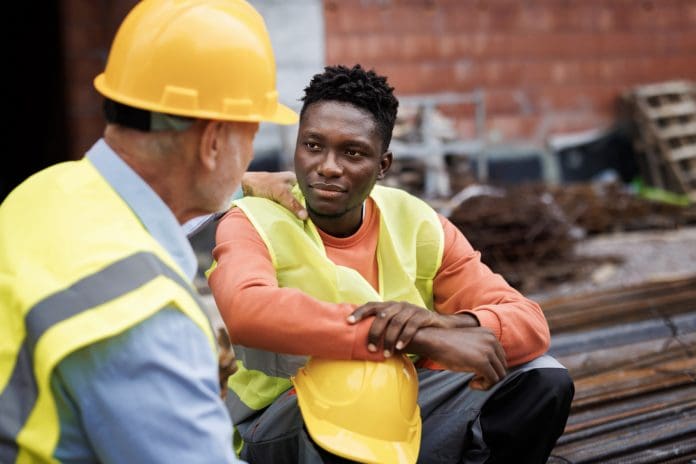 Senior man consoling his colleague at construction site