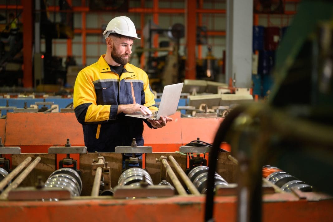Professional heavy industry technician engineer maintenance and check part of robot arm machine in intelligent factory with computer and walkie talkie. Industrial and technology support system concept The Build Chain investigates how digitising the construction materials procurement process can benefit your business