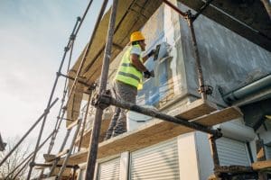 A construction worker builds the facade of a building