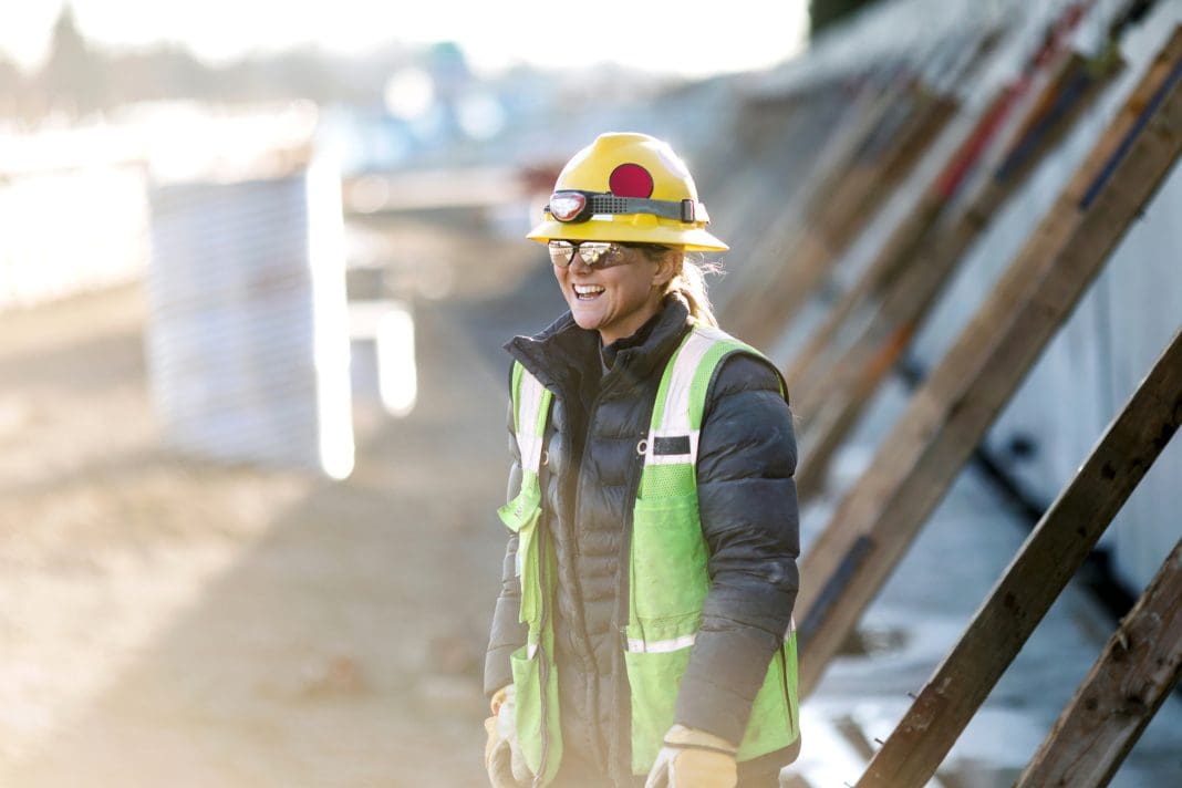 Woman Working In Construction Industry A female Caucasian laborer works on a large scale light-rail project in Washington state. A well paying trade job for a needed skillset.