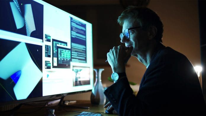 Close up stock photograph of a mature man working with a large computer screen. He’s working with 3D software examining complicated shapes representing the digital skills portal