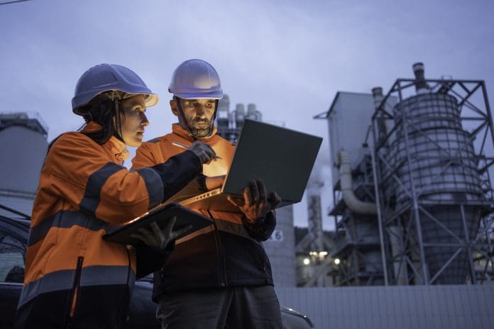 Man and woman working late with laptop in a power plant, representing nuclear site safety