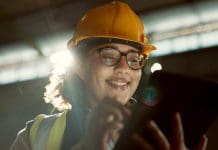 Smart construction and the rise of digital twins in the building industry Happy woman, engineer and tablet in warehouse for inspection, inventory or storage. Face of female person, architect or contractor smile on technology for quality control, communication or management