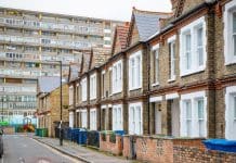 NatWest Group pledges £5bn to boost UK social housing sector Traditional English terraced houses with huge council block in the background in south east London