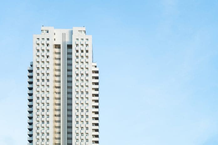 White modern skyscraper perfect symmetry with blue sky and copy space Front view of a white modern skyscraper perfect symmetry with blue sky and copy space. Architecture background concept