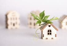 Retrofitting older homes for a greener future retrofit movement, future proofing homes, net zero carbon, adapting buildings concept. toy houses with green leaf on roof on white background.